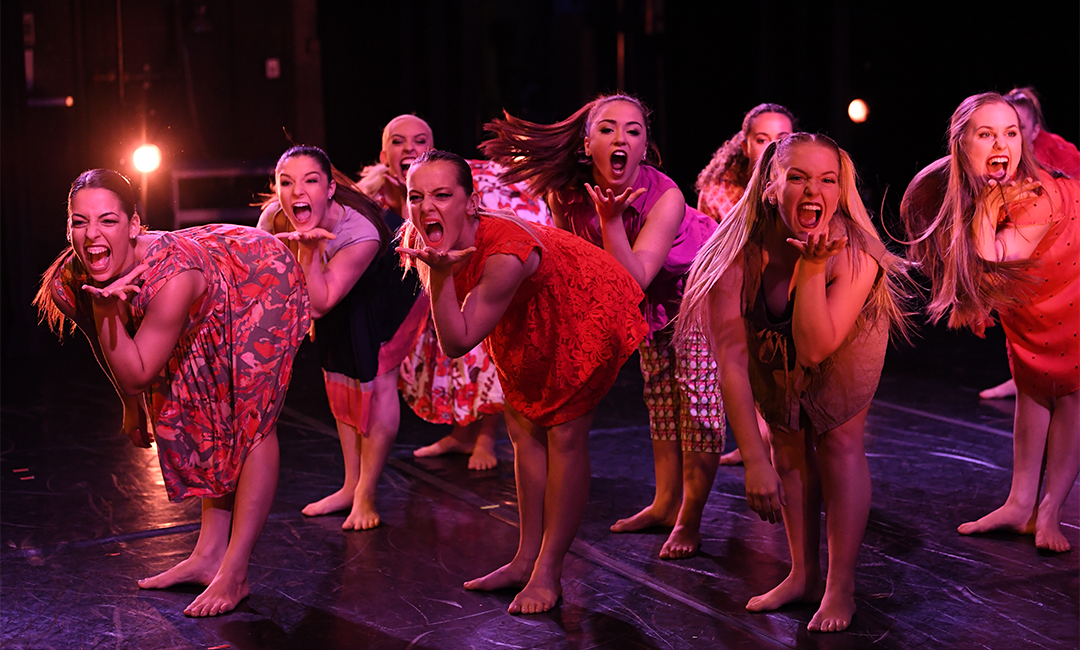 舞台上的一群女学生舞者正在进行一场富有表现力的表演