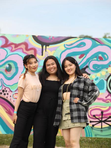Group of exchange students in front of a colorful mural.